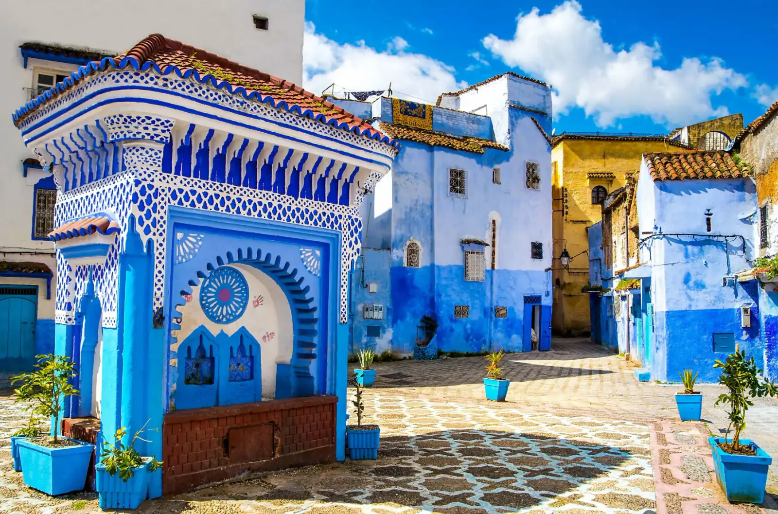 Vicolo blu con vasi di fiori nella medina di Chefchaouen