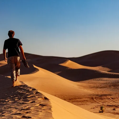 71456562--Africa-Morocco-Zagora-Sahara-Erg-Lehoudi-man-walking-over-sand-dune